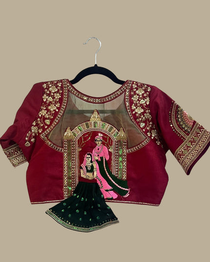 House Of Indian Wedding Attire maroon silk-like blouse with gold embroidery and sheer yoke, paired with a dark green skirt.
