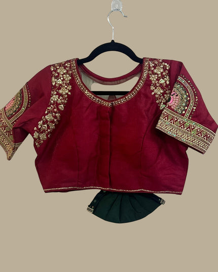 House Of Indian Wedding Attire maroon silk-like blouse with gold embroidery and matching dark green skirt.