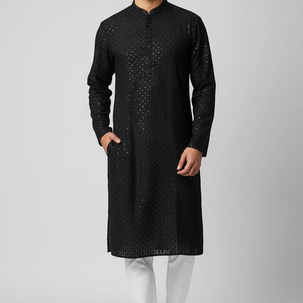 Man wearing a black Kurti Connection USA embroidered kurta with a mandarin collar and side pockets over white trousers