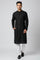 Man wearing a black Kurti Connection USA embroidered kurta with a mandarin collar and side pockets over white trousers