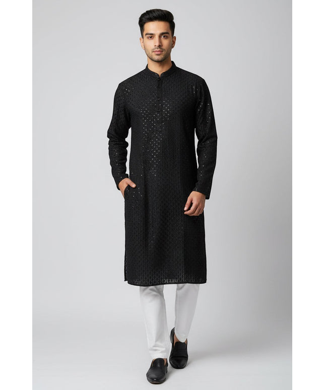 Man wearing a black Kurti Connection USA embroidered kurta with a mandarin collar and side pockets over white trousers