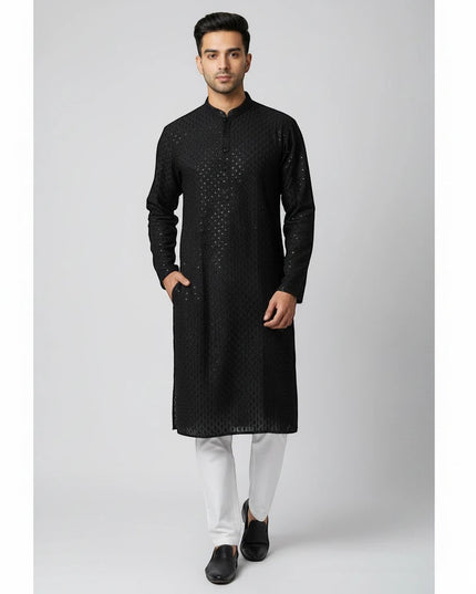 Man wearing a Kurti Connection USA black embroidered traditional kurta with a mandarin collar and white trousers.