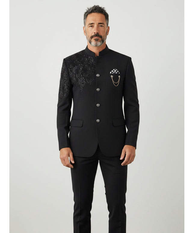Kurti Connection USA men's black Indo Western sherwani with intricate shoulder embroidery and a decorative chain brooch.