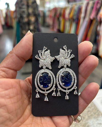 Kurti Connection USA oval deep blue gemstone dangle earrings with cubic zirconia halo and floral top.