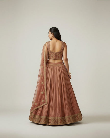 Kurti Connection USA embroidered lehenga set in warm hue with gold detailing. Features pleated skirt and ornate blouse.