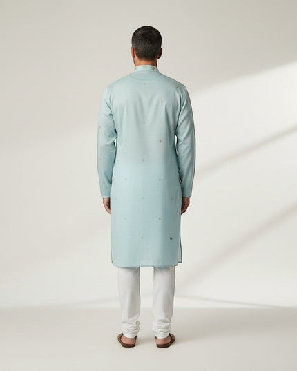 Kurti Connection USA light blue silk kurta set with subtle gold embroidery and white pajama, worn by a man.