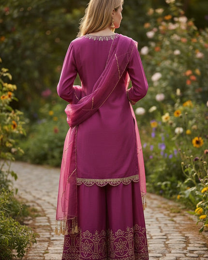 Kurti Connection USA magenta silk sharara suit with gold embroidery and scalloped hem. Model wears it outdoors.