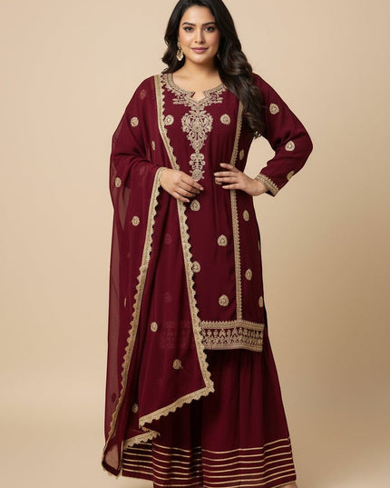 Model wearing a Kurti Connection USA maroon embroidered kurti and flared sharara set with a matching dupatta.