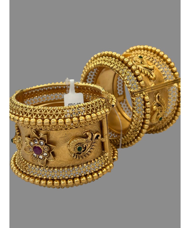 Kurti Connection USA ornate gold-tone bangle bracelets with peacock motifs, ruby and emerald stones, and filigree work.