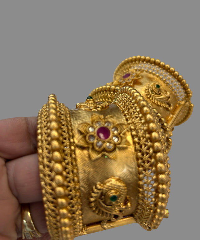 Kurti Connection USA ornate gold-tone bangle with floral motifs, peacock detailing, and ruby and emerald accents.