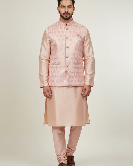 Man wearing a Kurti Connection USA peach kurta set with a patterned Nehru jacket and matching trousers.