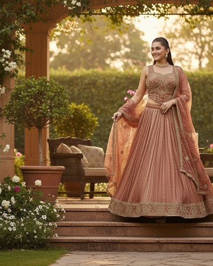 Kurti Connection USA woman in embroidered rose gold lehenga set with intricate gold detailing on blouse and skirt, perfect for special occasions.
