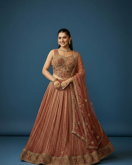 Kurti Connection USA woman in embroidered rose gold lehenga set with intricate gold detailing and matching dupatta.