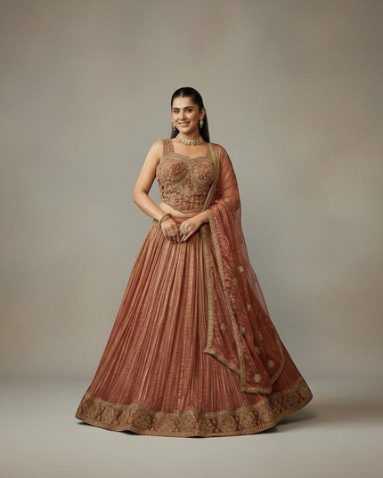 Kurti Connection USA embroidered lehenga set in warm rust with gold detailing. Sleeveless blouse and flowing pleated skirt.