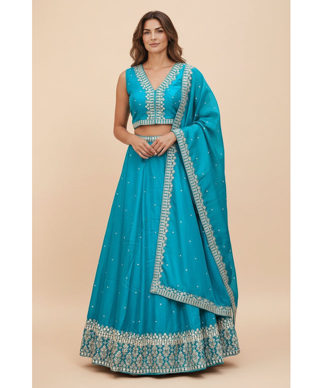 Model wearing a turquoise Kurti Connection USA lehenga choli set with silver embroidery and matching dupatta