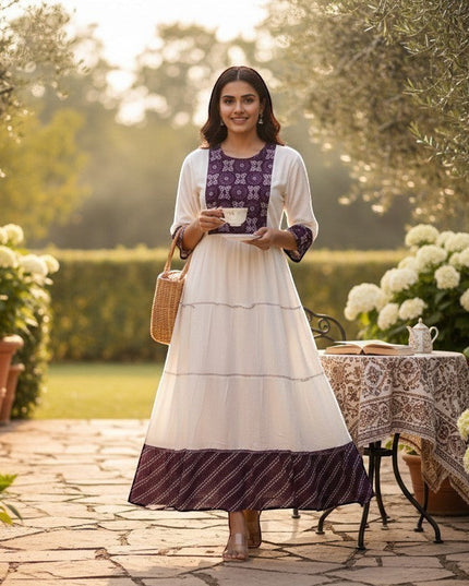 Kurti Connection USA white tiered maxi dress with purple embroidered yoke and cuffs, flowing silhouette, model holding teacup.