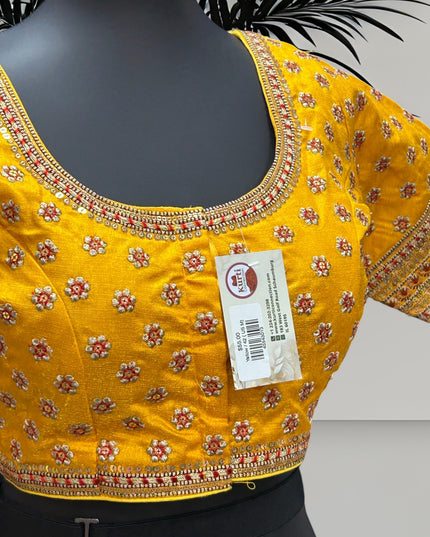 Kurti Connection USA yellow traditional blouse with intricate floral embroidery, sequin borders, and metallic thread.