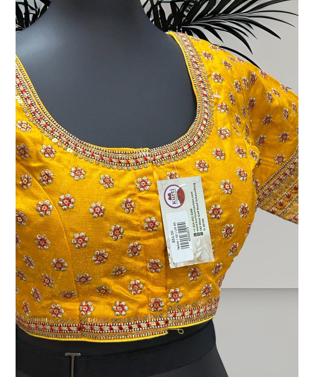 Kurti Connection USA yellow traditional blouse with intricate floral embroidery, sequin borders, and metallic thread.