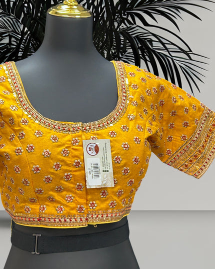 Kurti Connection USA yellow traditional blouse with floral embroidery, sequin borders, and metallic thread detailing.