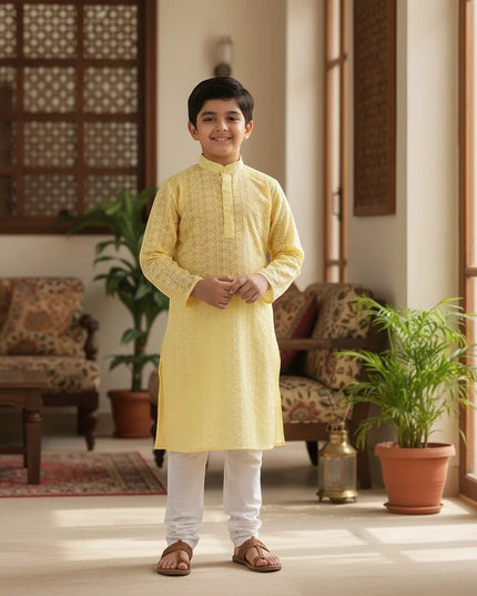 Kurti Connection USA boy wearing a yellow embroidered kurta with white churidar trousers in a bright living room